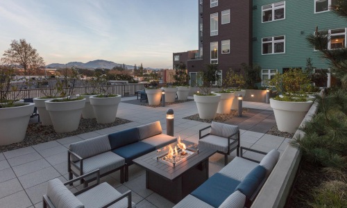 rooftop patio with a fire pit and chairs