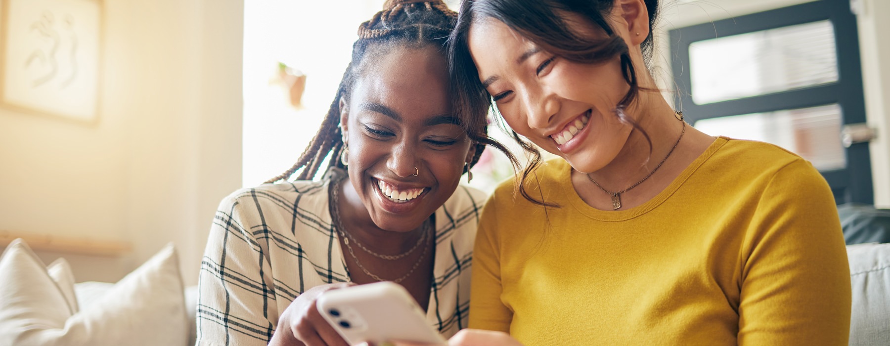two woman looking at a phone