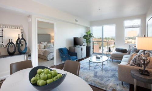 a living room with a large glass door to private balcony