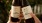 hands holding bottles of kombucha