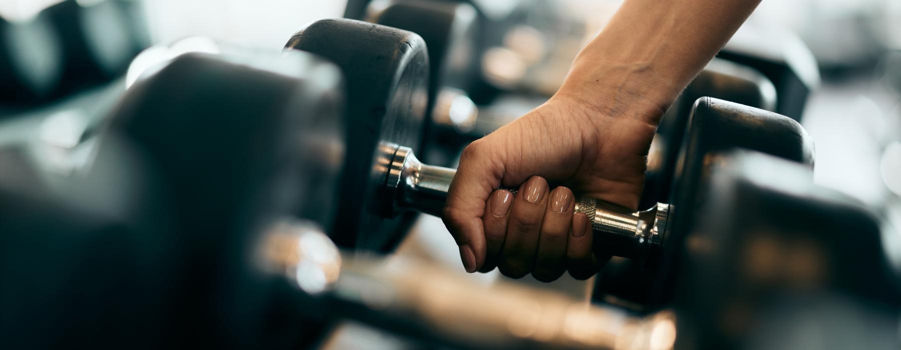 a close-up of a hand grabbing a dumbell