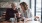 two women sitting at a table looking at a phone